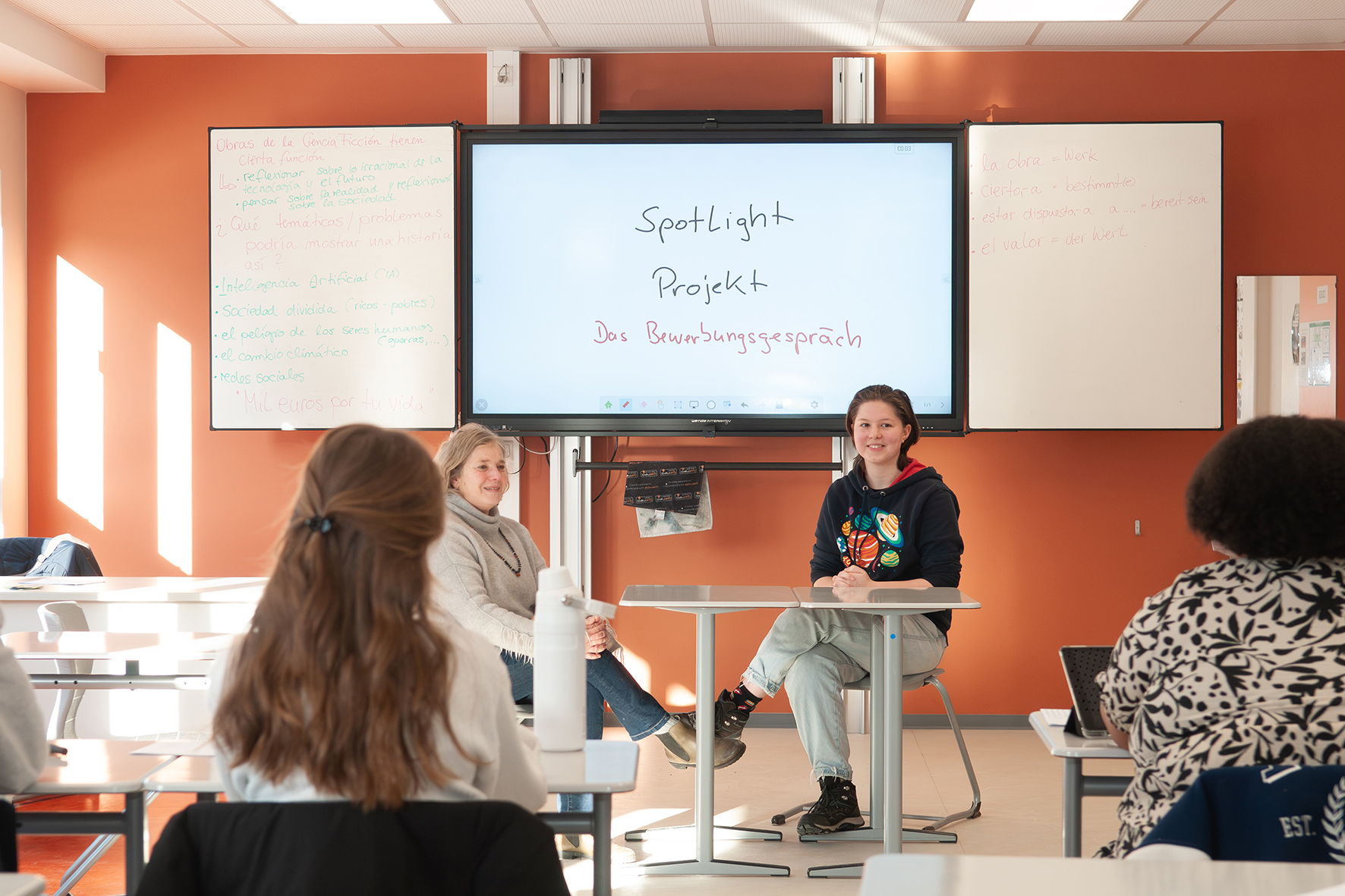 Bewerbungstraining Jugendliche sitzen in einem Klassenraum vor einem Bildschirm mit der Aufschrift 'Spotlight Projekt Das Bewerbungsgespräch'
